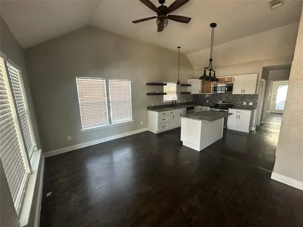 a kitchen with a sink a stove cabinets and wooden floor