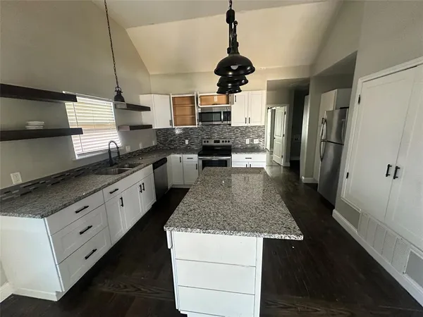 a kitchen with stainless steel appliances granite countertop a sink a stove and refrigerator