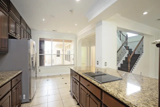 a kitchen with granite countertop a sink a stove and a wooden floor