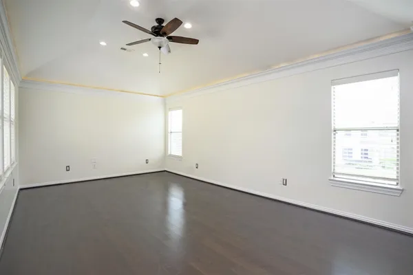 an empty room with a window and a ceiling fan
