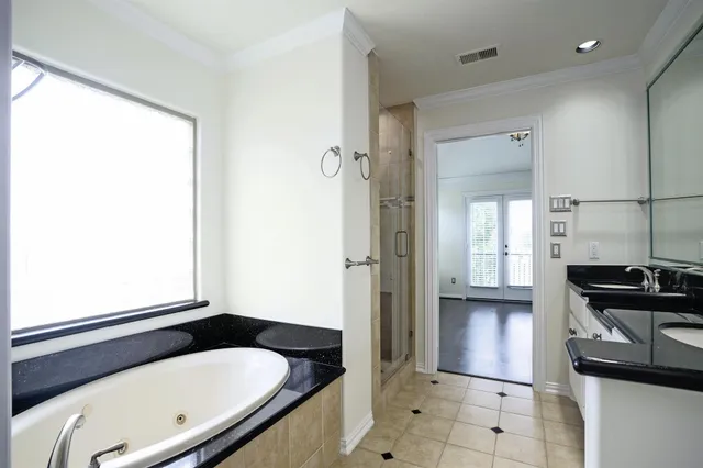 a bathroom with a tub a sink and a window