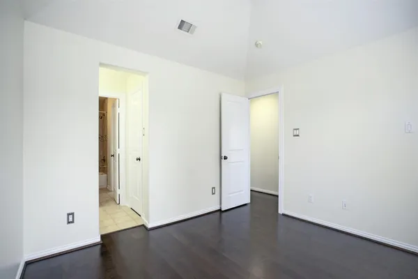 an empty room with wooden floor and closet