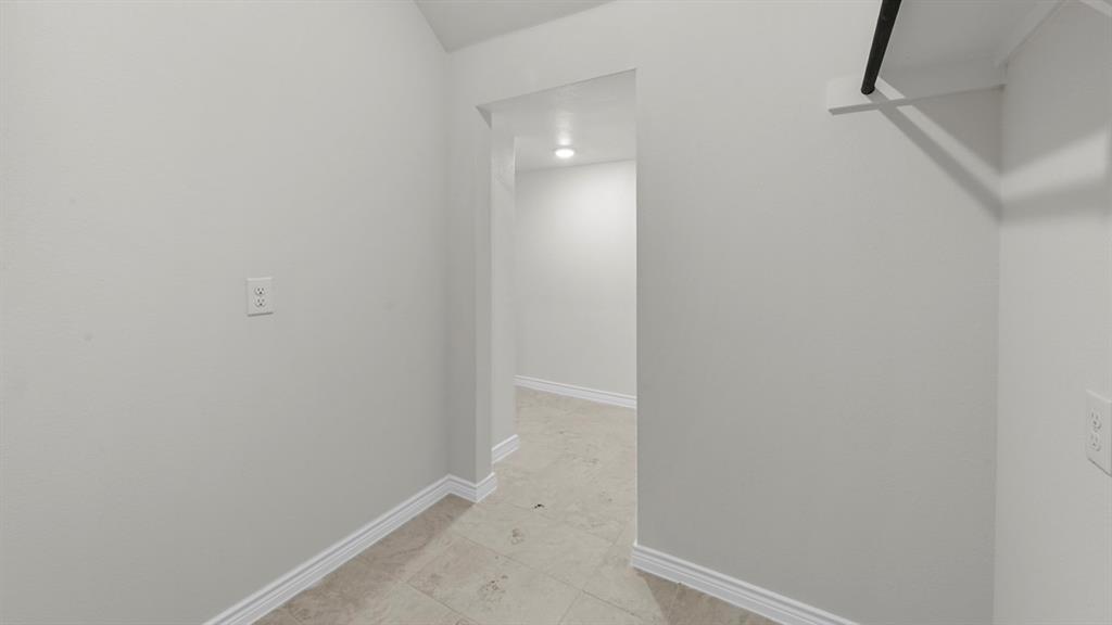 412 Carthage Street Caddo Mills, TX 75135 - Photo 18 of 32 Hallway featuring light-toned tile flooring, white baseboards, and a built-in hanging rod