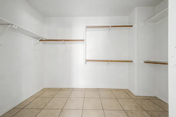 a view of an empty room and window and chandelier fan