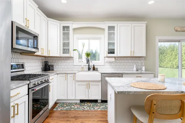 a kitchen with granite countertop a sink a stove a microwave and wooden cabinets