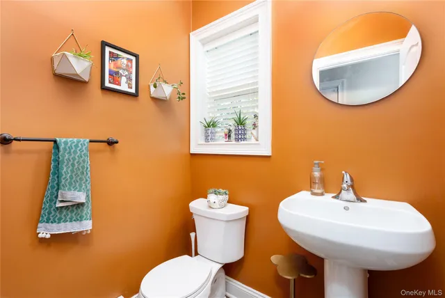 a bathroom with a toilet a sink and mirror