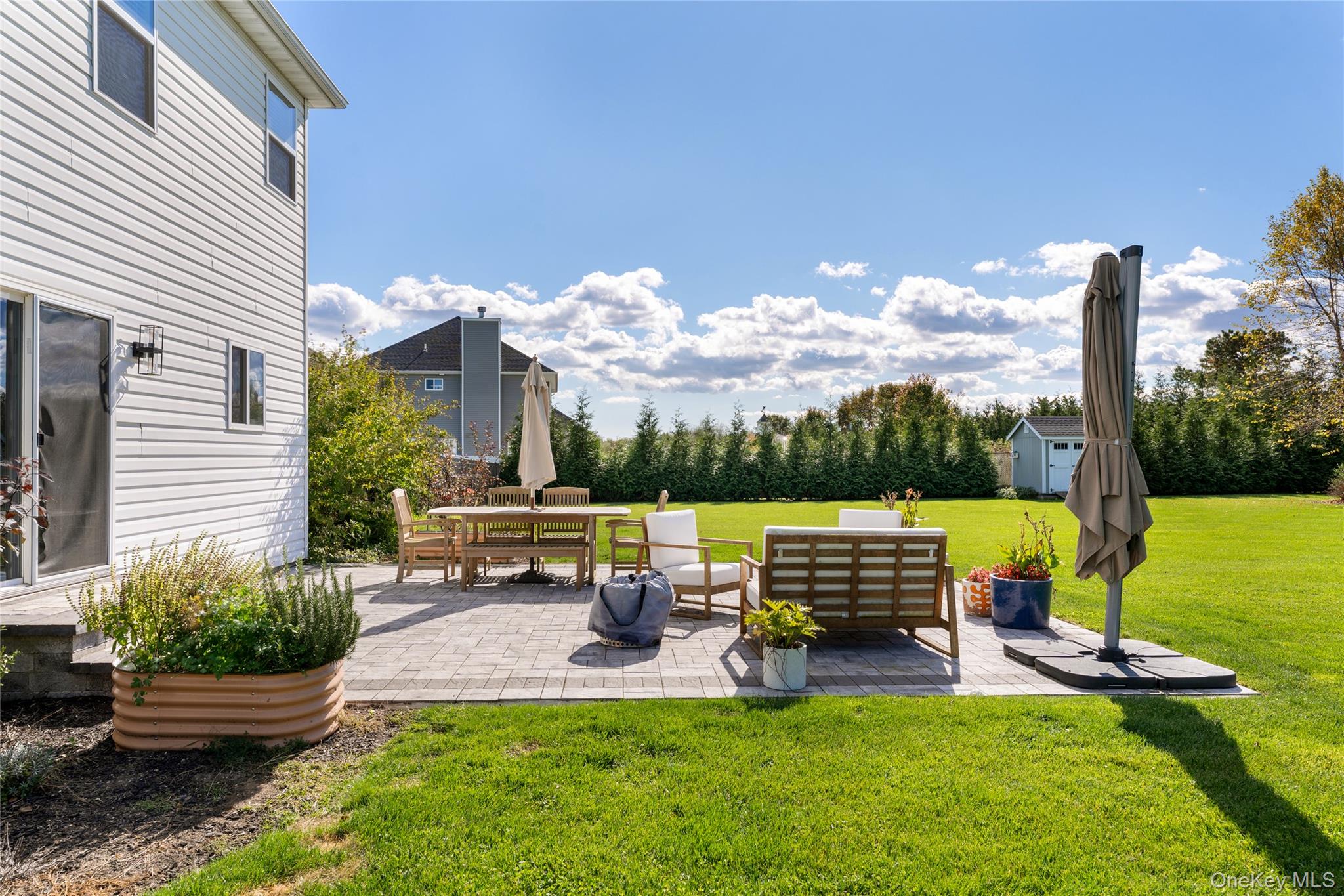108 Calverton Court Wading River, NY 11792 - Photo 27 of 36 a view of a patio with table and chairs potted plants and palm tree