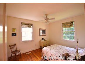 231 Woodland Road Tryon, NC 28782 - Photo 22 of 24 a bedroom with a bed and wooden floor