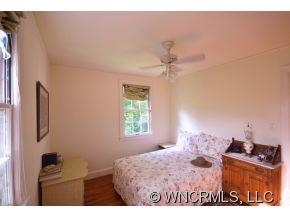 231 Woodland Road Tryon, NC 28782 - Photo 23 of 24 a bedroom with a bed and a dresser in it