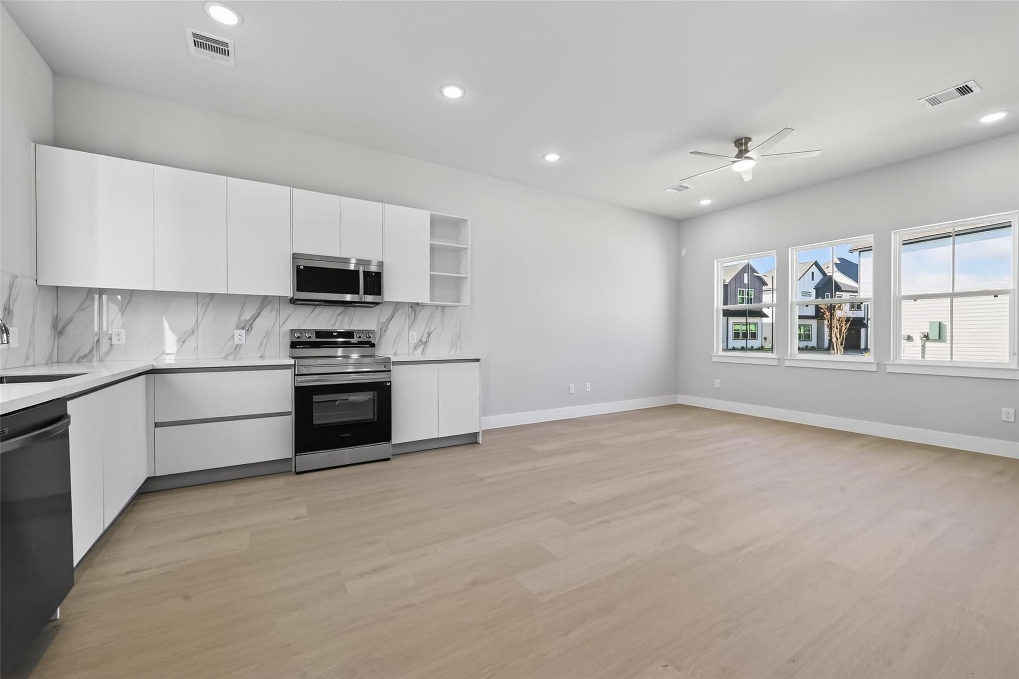6702 Metro Boulevard, Unit 8 Houston, TX 77083 - Photo 12 of 36 a kitchen with stainless steel appliances kitchen island granite countertop a stove a sink and a refrigerator