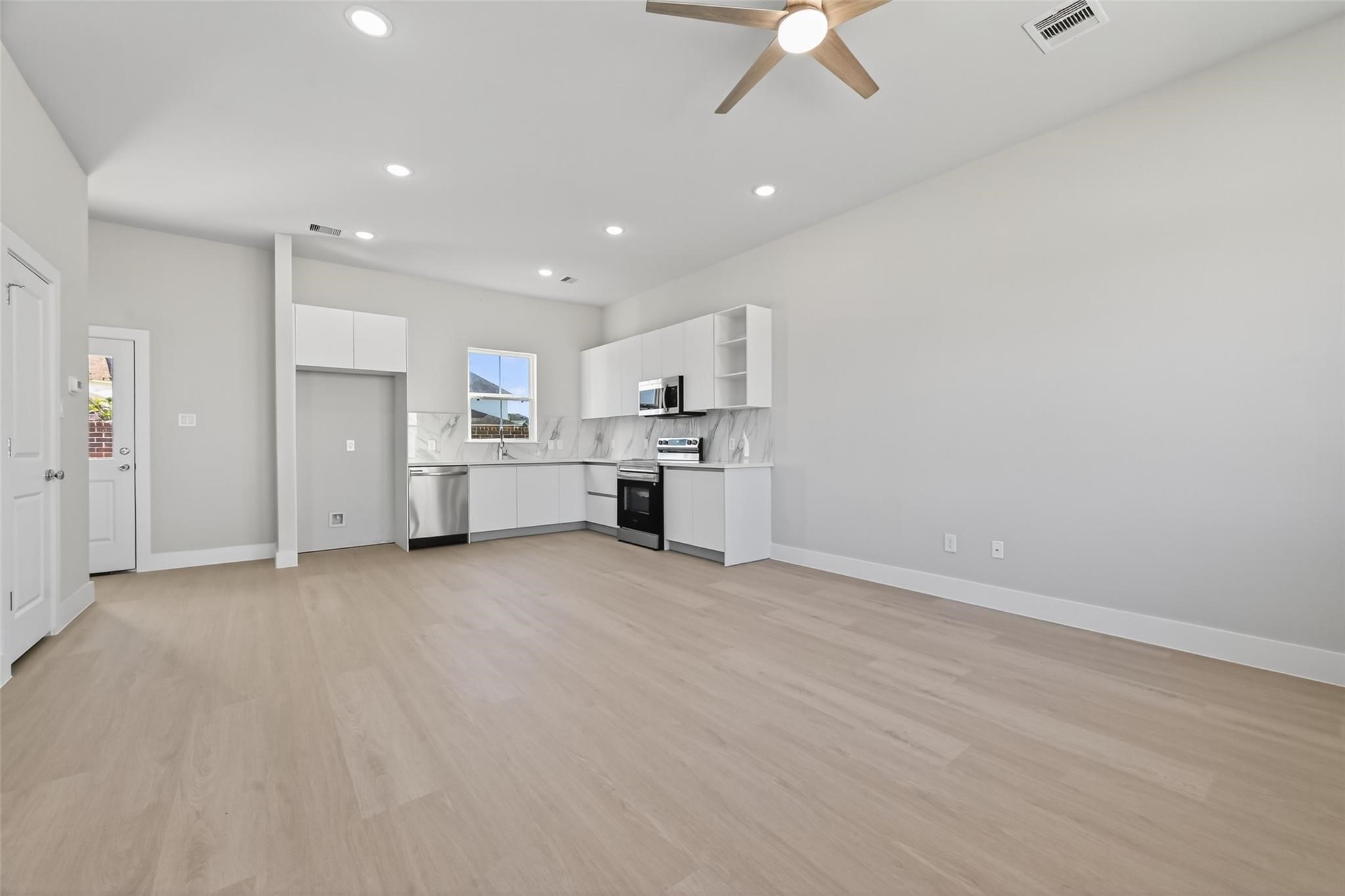 6702 Metro Boulevard, Unit 8 Houston, TX 77083 - Photo 5 of 36 an empty room with kitchen and ceiling fan