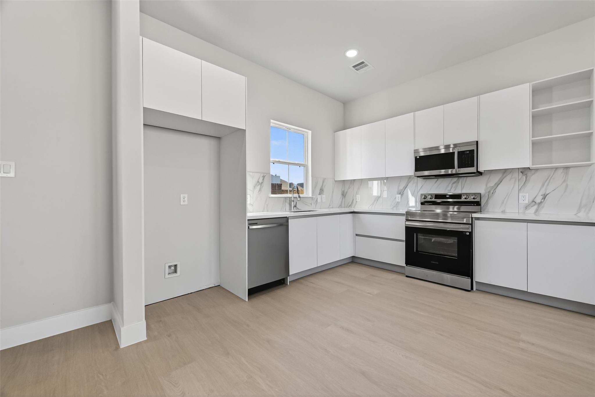 6702 Metro Boulevard, Unit 8 Houston, TX 77083 - Photo 6 of 36 a kitchen with a stove a sink and a refrigerator