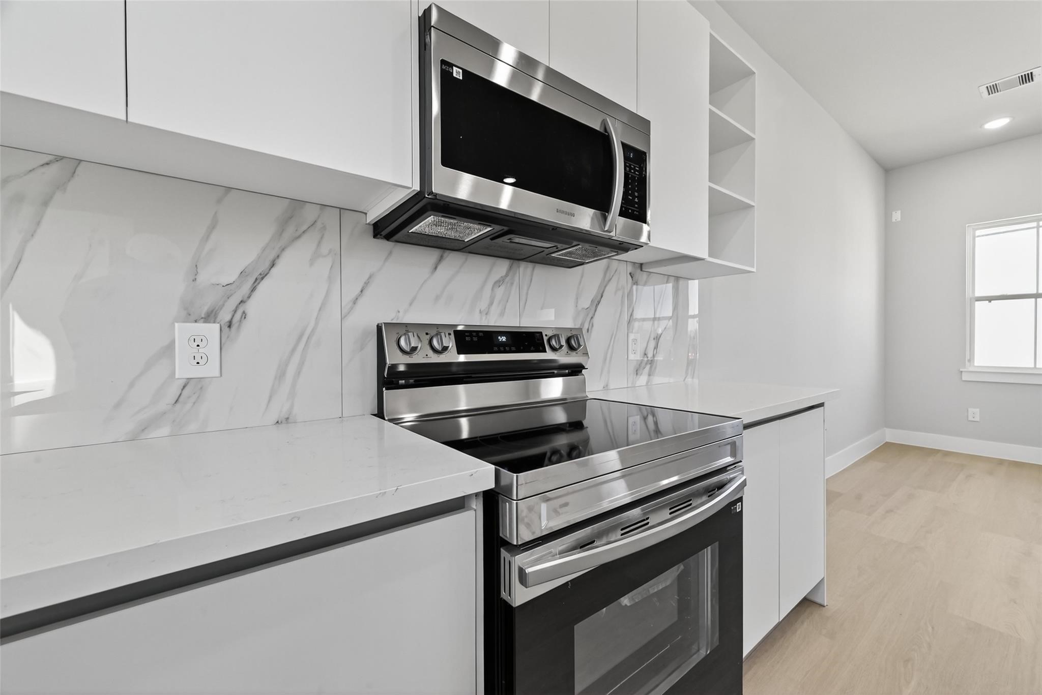 6702 Metro Boulevard, Unit 8 Houston, TX 77083 - Photo 10 of 36 a kitchen with stainless steel appliances a stove microwave and sink
