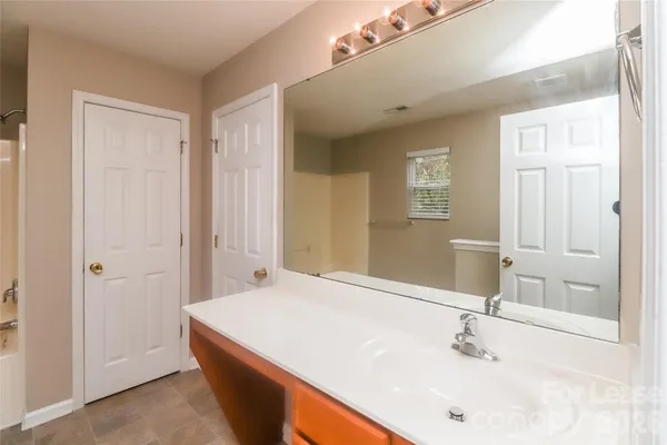 a bathroom with a tub sink and mirror