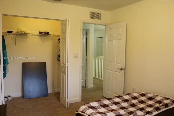 a bedroom with a bed and a mirror on dresser