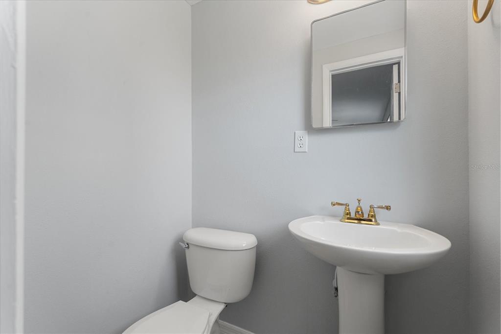 4070 McNeil Road Apopka, FL 32703 - Photo 15 of 28 a bathroom with a toilet sink and mirror
