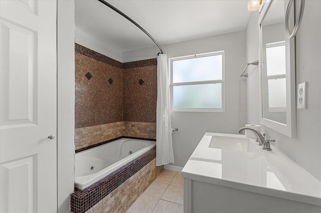 4070 McNeil Road Apopka, FL 32703 - Photo 16 of 28 a bathroom with a sink a mirror and a bathtub