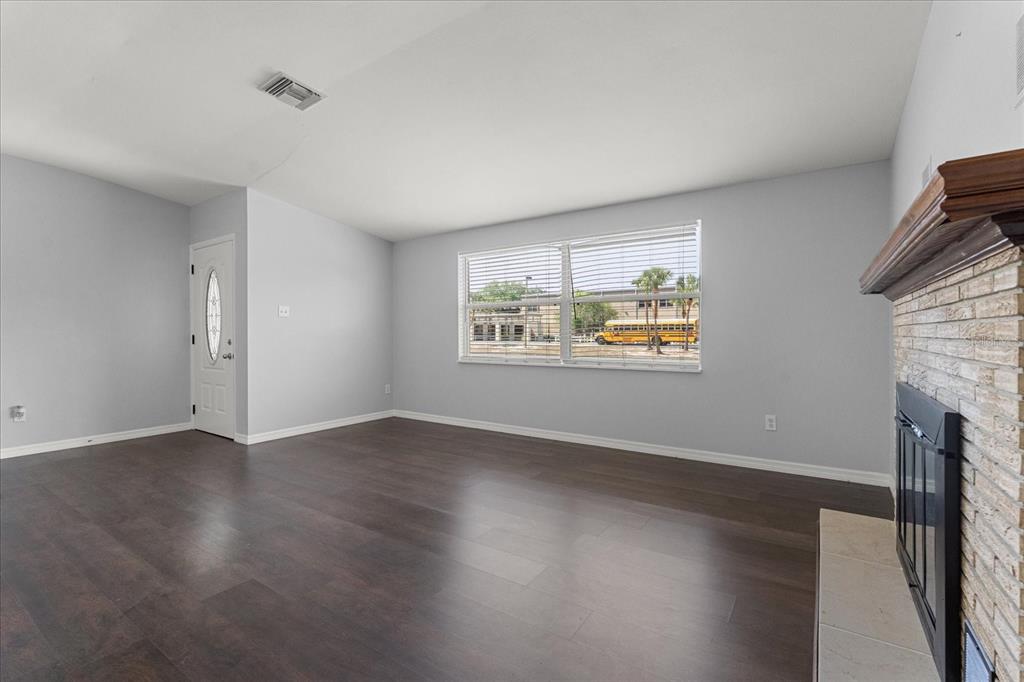 4070 McNeil Road Apopka, FL 32703 - Photo 4 of 28 an empty room with windows fireplace and wooden floor