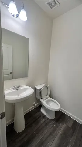 a view of a room with wooden floors and white walls