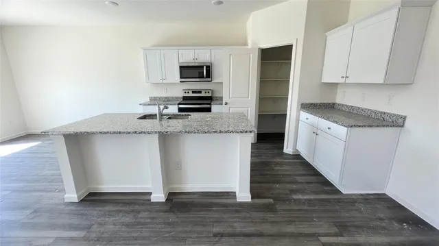 a kitchen with granite countertop a sink and steel appliances
