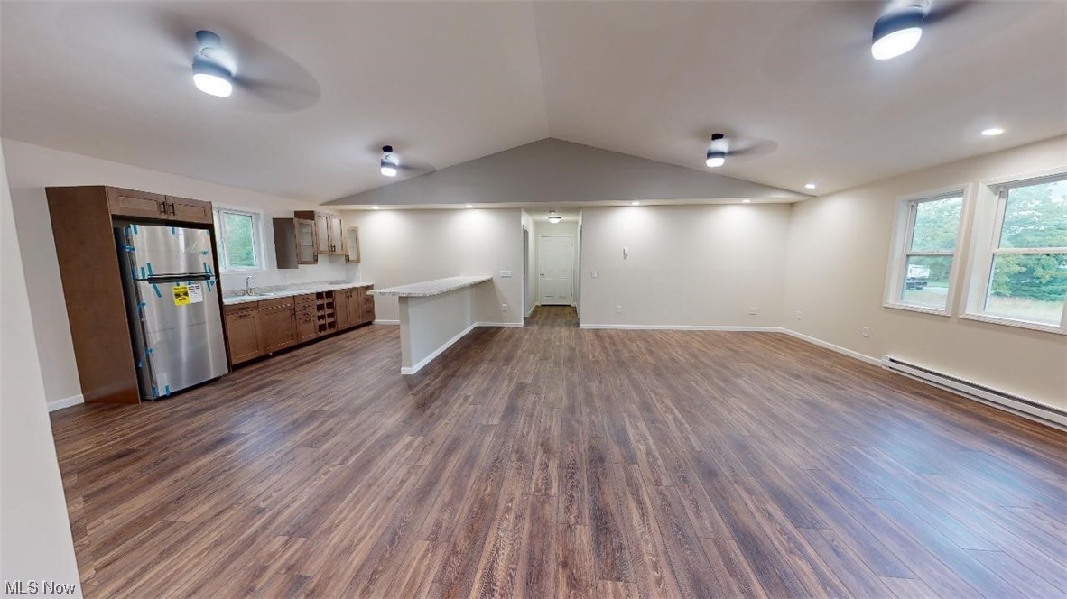 1715 Chenango Road Wakeman, OH 44889 - Photo 16 of 21 Kitchen with vaulted ceiling, a baseboard heating unit, ceiling fan, stainless steel fridge, and dark hardwood / wood-style floors