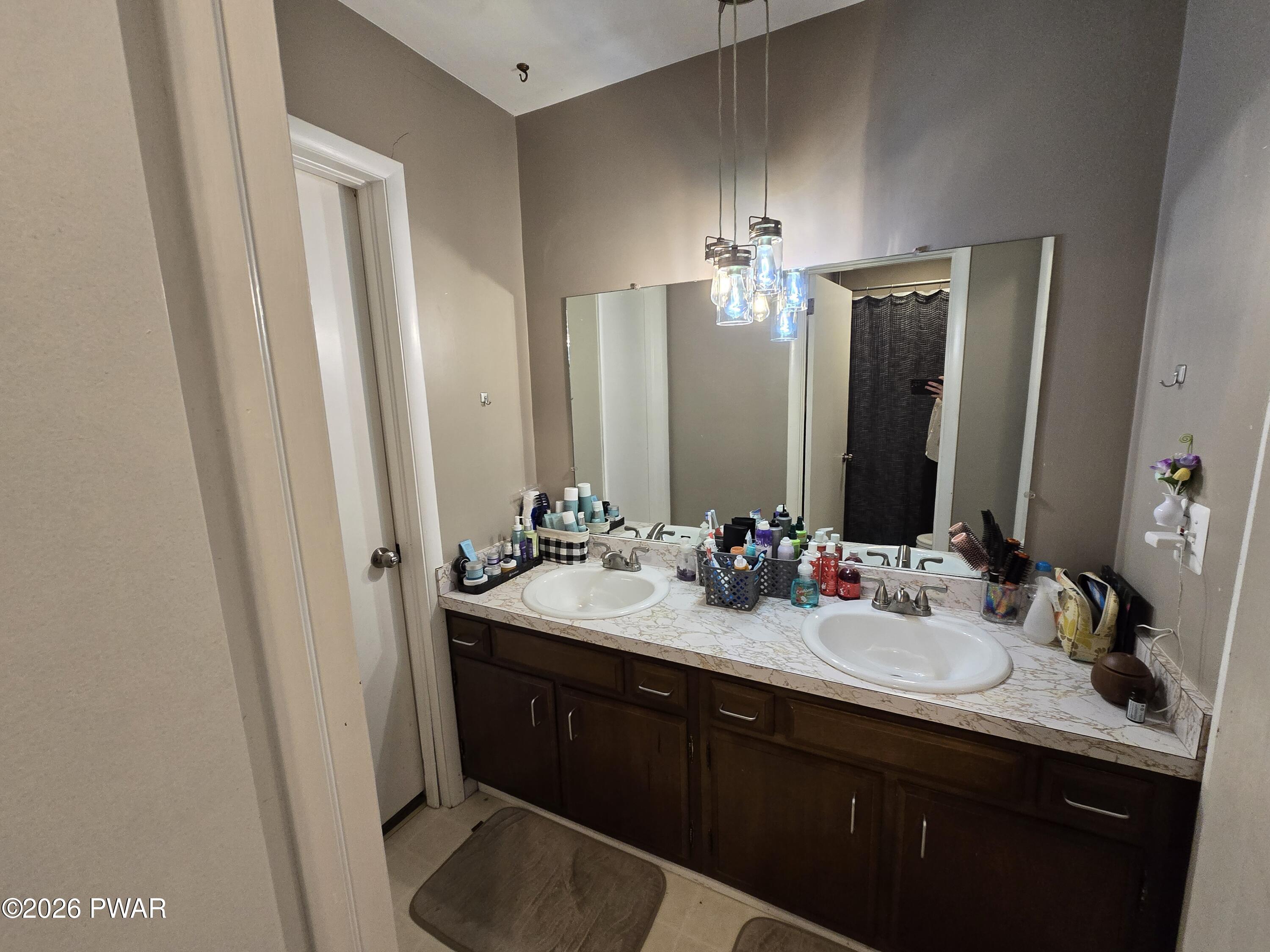 107 Keystone Hls Road, Unit 404 Factoryville, PA 18419 - Photo 19 of 23 a bathroom with a double vanity sink and a mirror