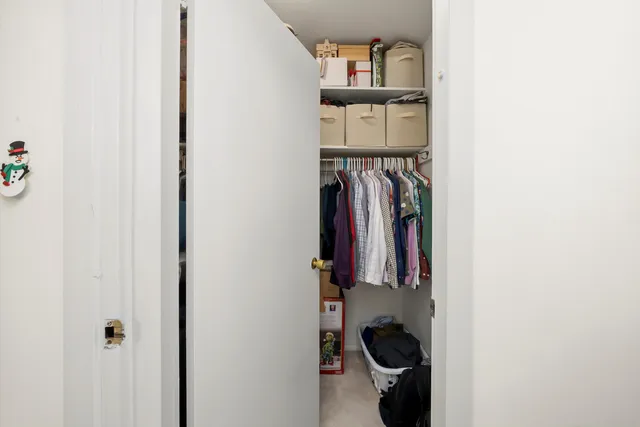 a view of walk in closet with clothes and shoes