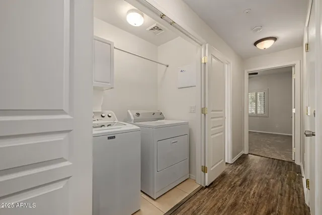 a view of utility room with closet and wooden floor