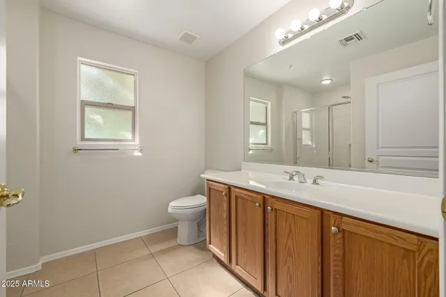 a spacious bathroom with a toilet sink and mirror