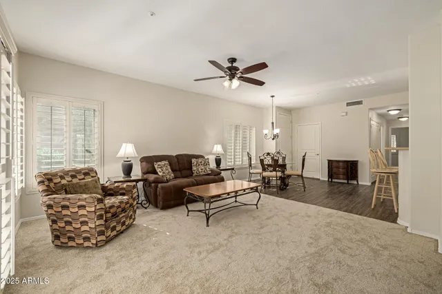 a living room with furniture ceiling fan and a window