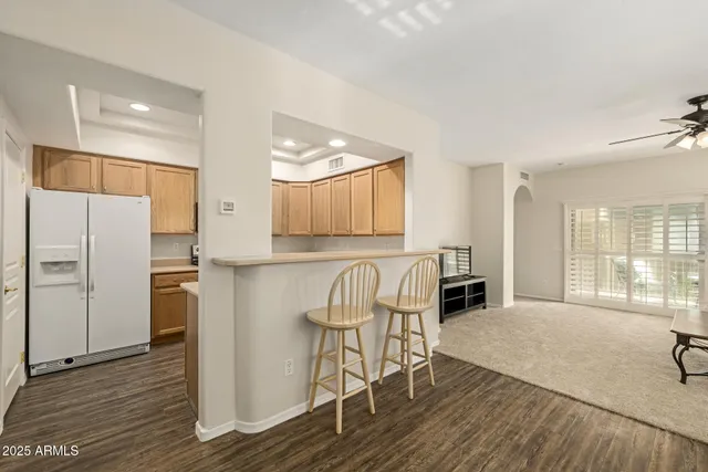 a kitchen with stainless steel appliances granite countertop a refrigerator a stove a sink and a dining table with wooden floor