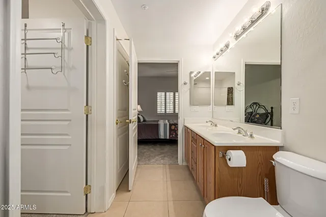 a bathroom with a granite countertop sink mirror vanity and toilet