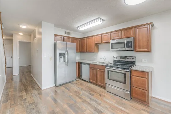 a kitchen with stainless steel appliances granite countertop a refrigerator stove and sink