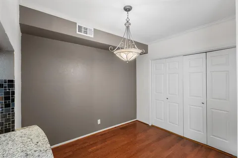 a view of a room with a chandelier fan and wooden floor