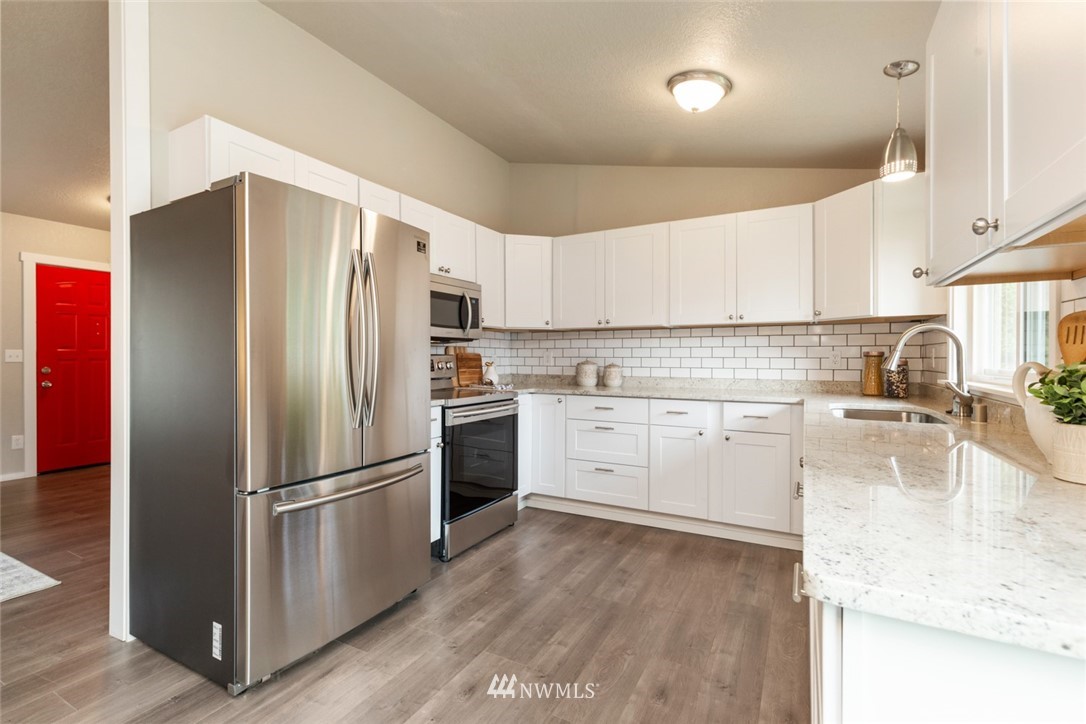 20711 Filbert Drive Bothell, WA 98012 - Photo 11 of 25 a kitchen with a refrigerator a sink and a stove top oven