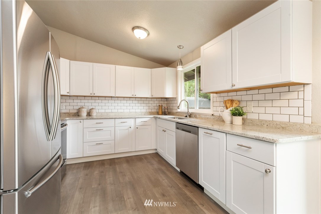 20711 Filbert Drive Bothell, WA 98012 - Photo 10 of 25 a kitchen with granite countertop white cabinets and white appliances