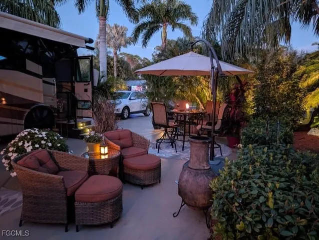 a view of a patio with dining table and chairs under an umbrella with a fire pit