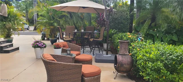 a view of a patio with table and chairs potted plants