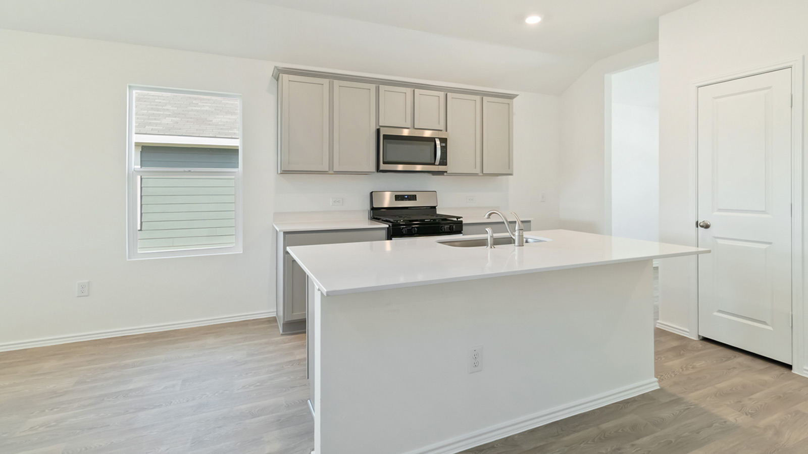 265 Balmorhea Street Kyle, TX 78640 - Photo 11 of 25 a kitchen with a sink cabinets and a window
