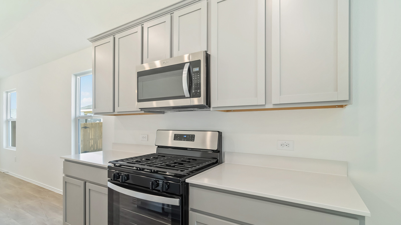 265 Balmorhea Street Kyle, TX 78640 - Photo 14 of 25 a kitchen with stainless steel appliances granite countertop white cabinets and a stove top oven