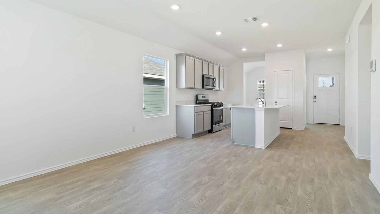 265 Balmorhea Street Kyle, TX 78640 - Photo 9 of 25 a view of a kitchen with a sink and dishwasher a refrigerator with wooden floor