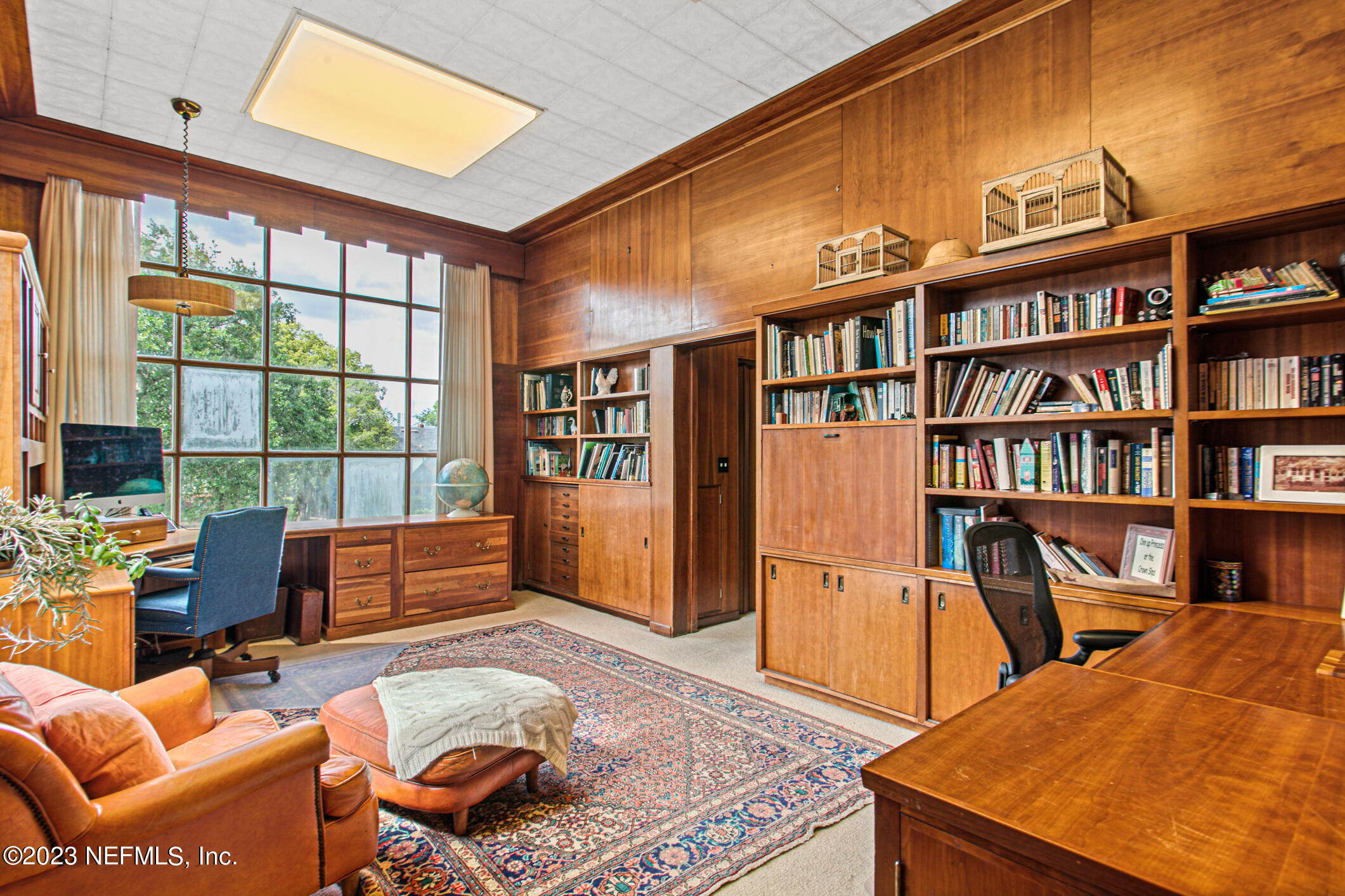2103 River Road Jacksonville, FL 32207 - Photo 25 of 67 a living room with furniture a bookshelf and a book shelf