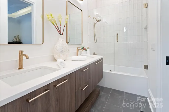 a bathroom with a double vanity sink a mirror and a bathtub