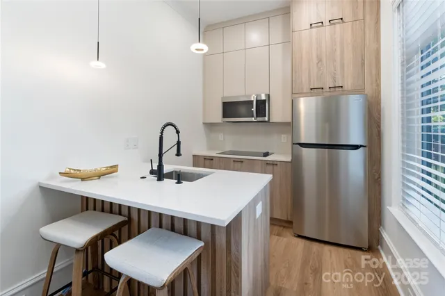 a kitchen with stainless steel appliances a sink refrigerator and microwave