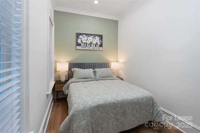 a bedroom with a bed and a painting on the wall