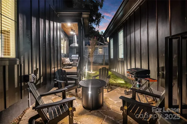 an outdoor living room with furniture and floor to ceiling windows