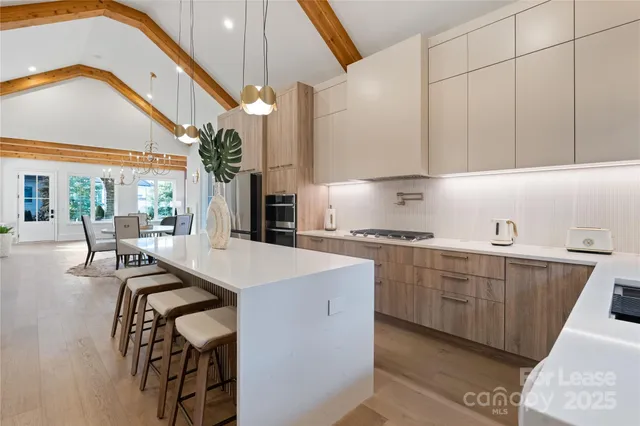 a kitchen with a table chairs sink and cabinets
