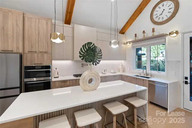 a kitchen with a table chairs and white cabinets