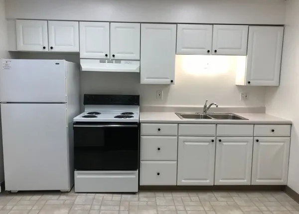 a kitchen with granite countertop white cabinets and white appliances