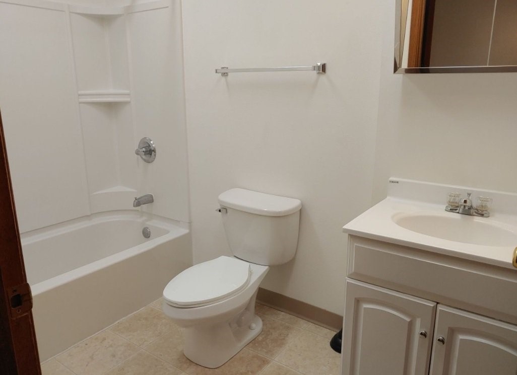 2202 Broadway Street Granger, IA 50109 - Photo 6 of 11 a white toilet sitting next to a bath tub